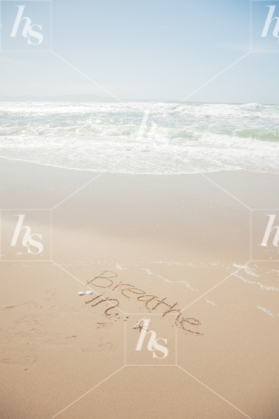 Stock photo by Haute Stock with the word Breathe In written in the sand and waves crawling into the shore