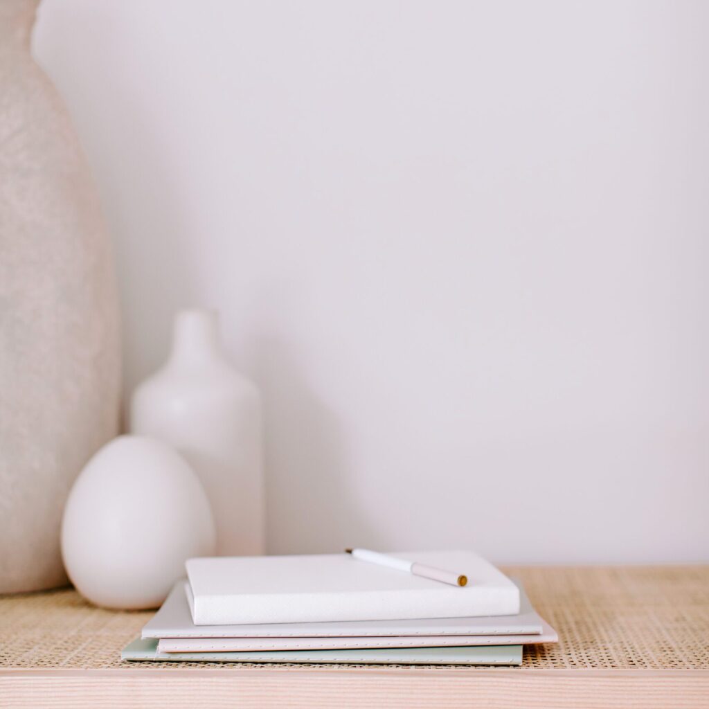 Stock photography image of boho home decor and pile of notebooks and pen.