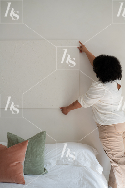 Mockup stock image featuring interior designer hanging up blank canvas onto the wall. Image perfect for creatives and designers.