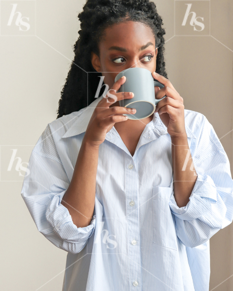 A woman in blue drinking coffee as a lifestyle image for entrepreneurs
