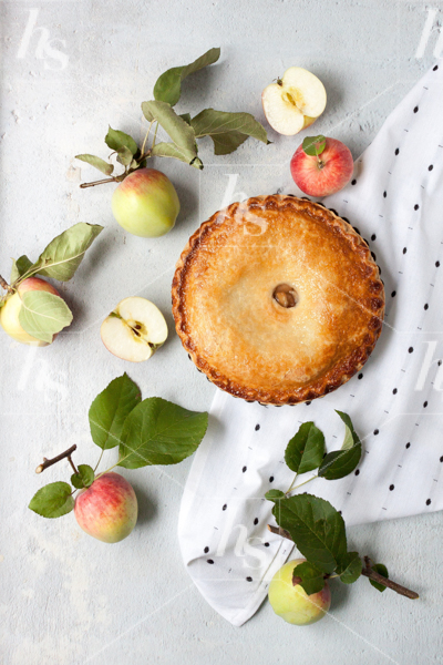 Apple pie with beautiful apples surrounding the pie is the perfect fall stock photo for lifestyle bloggers