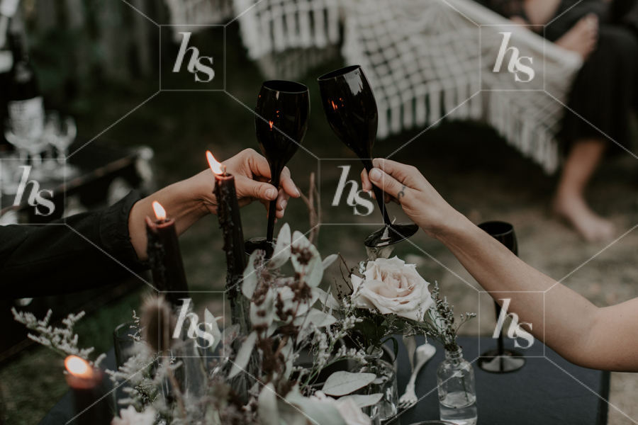 Moody witchy stock image featuring women cheersing glasses.