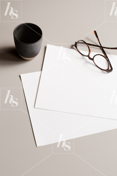 Stock photo of blank stationery paper, reading glasses and black coffee mug, part of Mockups collection by Haute Stock