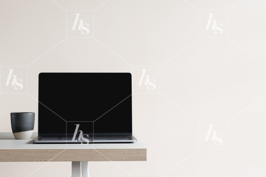 Blank Laptop screen on desk with neutral color wall as background