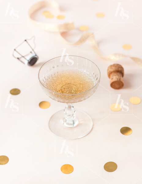 Haute Stock photo perfect for your holiday events featuring a glass of bubbly and cork on taupe background