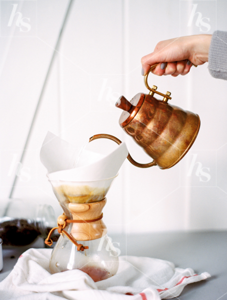 Woman pouring fresh made coffee from a copper kettle