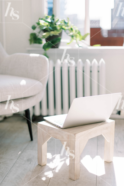 laptop on stool in front of the a chair as a relaxing workspace stock photos