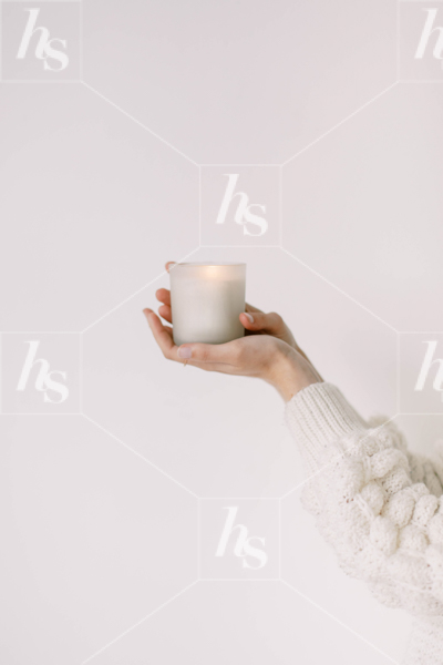 Minimal stock image showing a woman's hand holding a lit candle, part of Haute Stock lifestyle collection