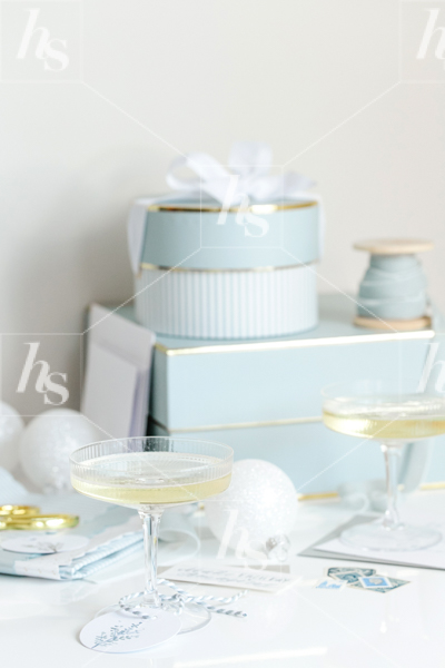 Blue gift boxes, champagne glasses and white ornaments, a perfect stock photo by Haute Stock for your holiday branding