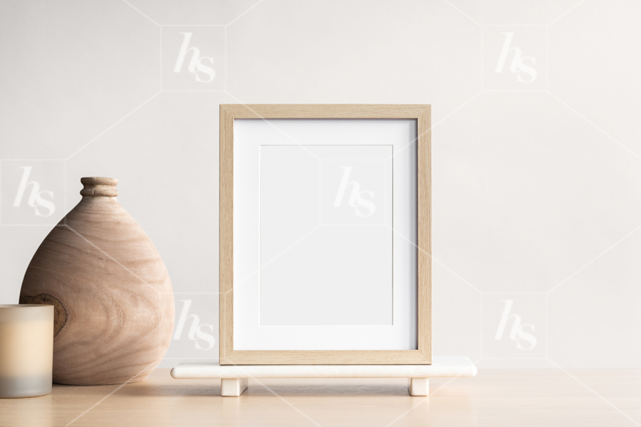 Styled stock photo of a simple wood frame mockup on neutral table perfect to display your designs and brands.