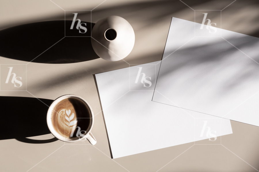 Flatlay stock image of paper mockups on taupe background with latte perfect for creative designs