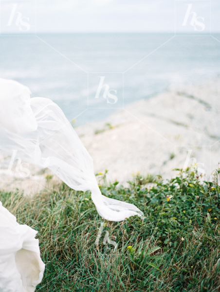Soft fabric blowing in wind against coastal scene, stock photography for travel bloggers