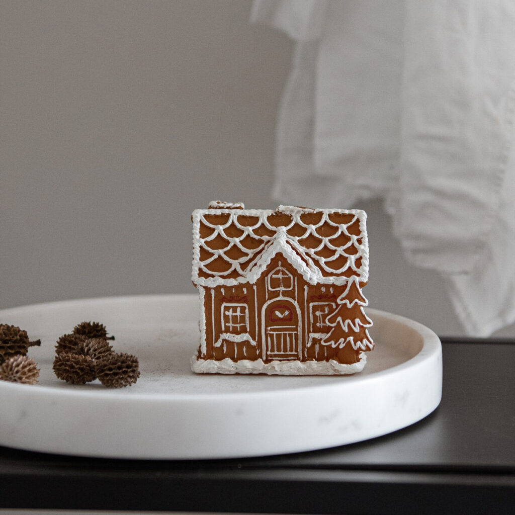 Styled stock image of gingerbread house on marble tray next to acorns, perfect for your holiday marketing