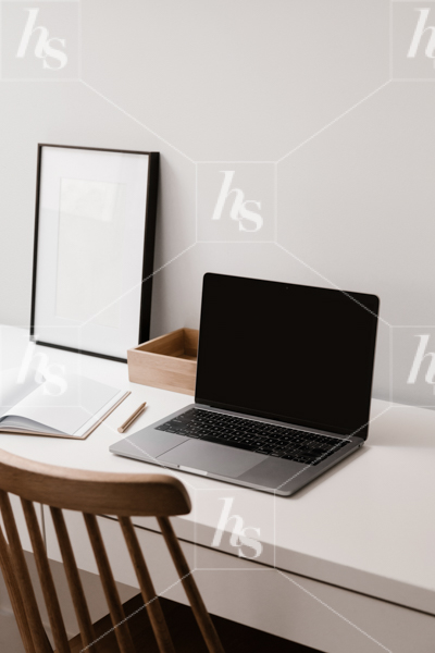 Styled workspace photo featuring laptop mockup on desk with notebook and frame