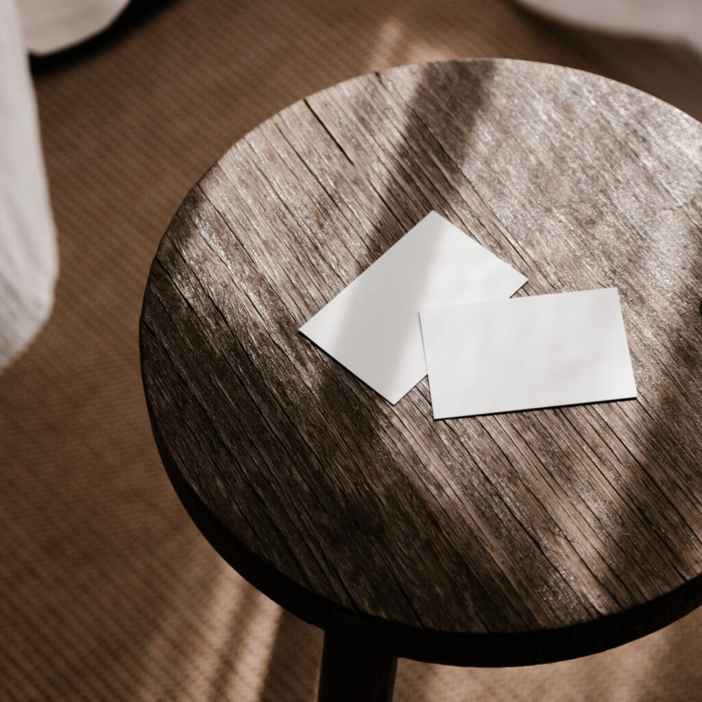 Stock photo of business cards mockup on a shadowy dark brown wooden stool, perfect for product designer. From Haute Stock's Minimalist Mockups and Flat Lays Collection from Moyo Studio