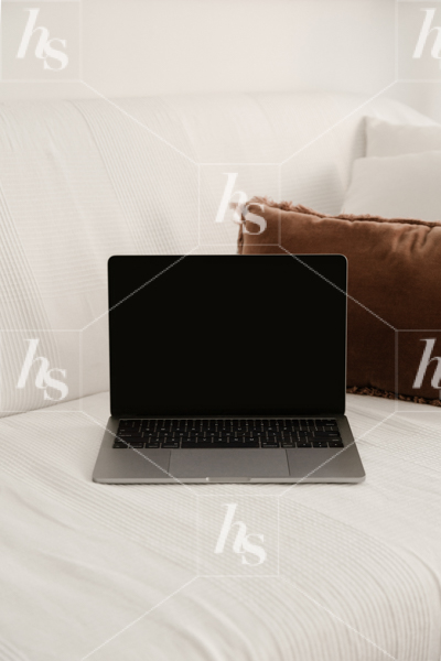 Working from home, this image features Laptop mockup on comfy white couch
