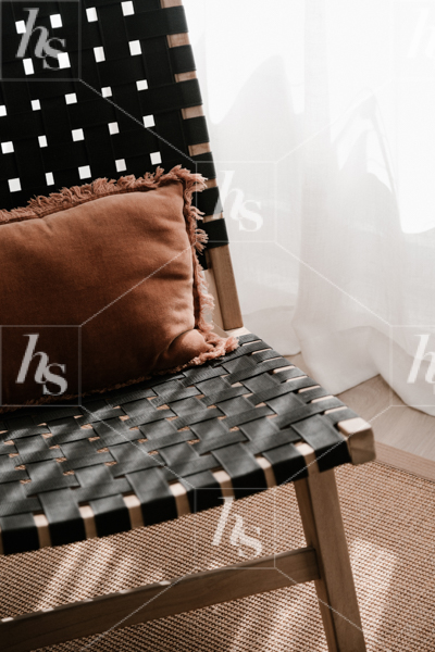 Home decor stock image by Haute Stock featuring brown pillow on black chair with white curtain in the background