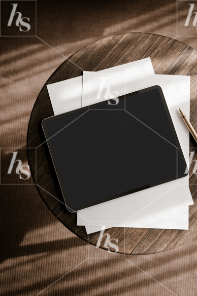 Flatlay of iPad mockup on dark wooden stool, perfect for your social media graphics