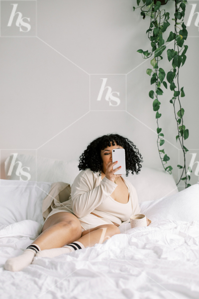 Woman chatting on phone while on bed, as part of Haute Stock wellness collection