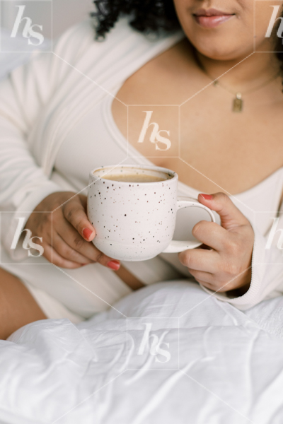 Lifestyle stock photo featuring close-up of woman in bed with coffee
