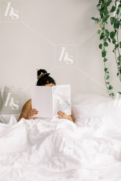 Woman reading a magazine in bed, relaxing    work from home stock images