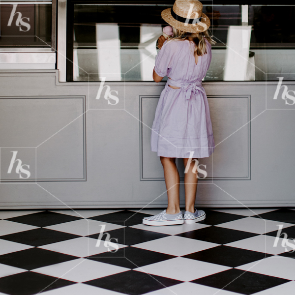 Stock image of a girl in purple dress enjoying an ice cream cone inside an ice cream parlour. perfect images for seasonal, lifestyle and motherhood brands.