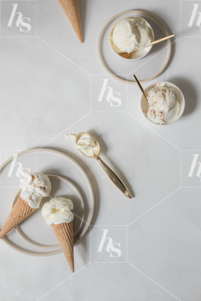 Vanilla ice cream in cones and bowls on flatlay, perfect for your summer promotional graphics.
