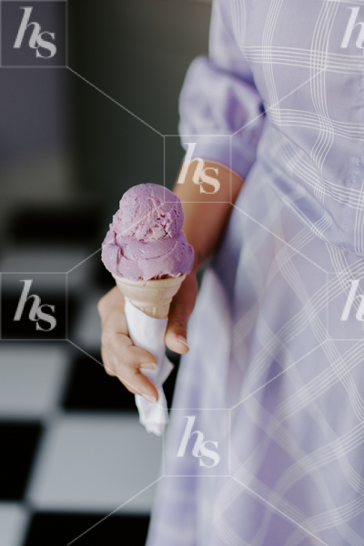 Stock image of a woman in purple dress holding purple ice cream. Fun stock images for seasonal promotional graphics.