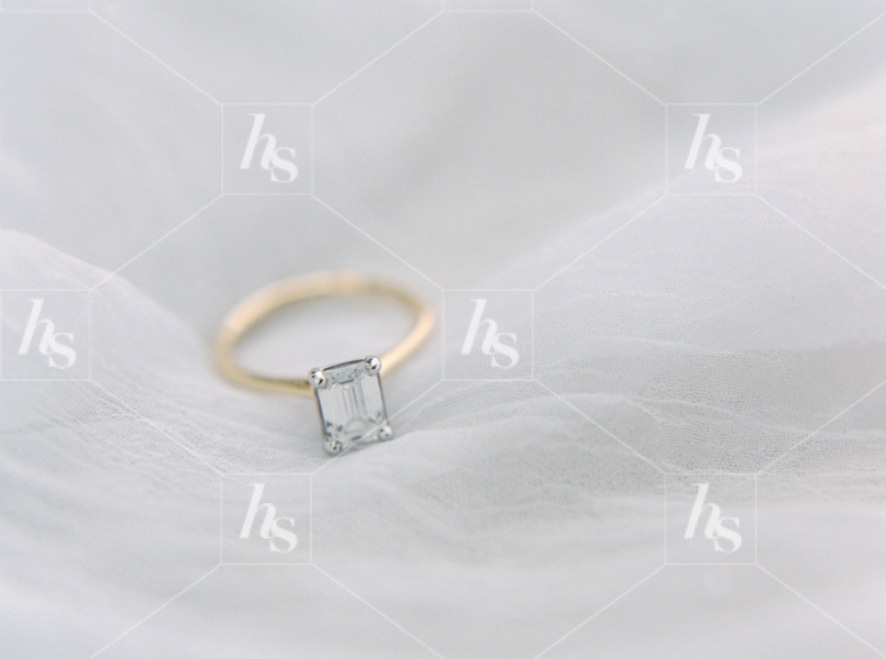 Engagement ring on white fabric, a perfect stock image for Valentine's Day celebration.