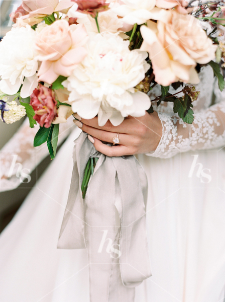 Stock image featuring a bride holding bouquet of flowers.