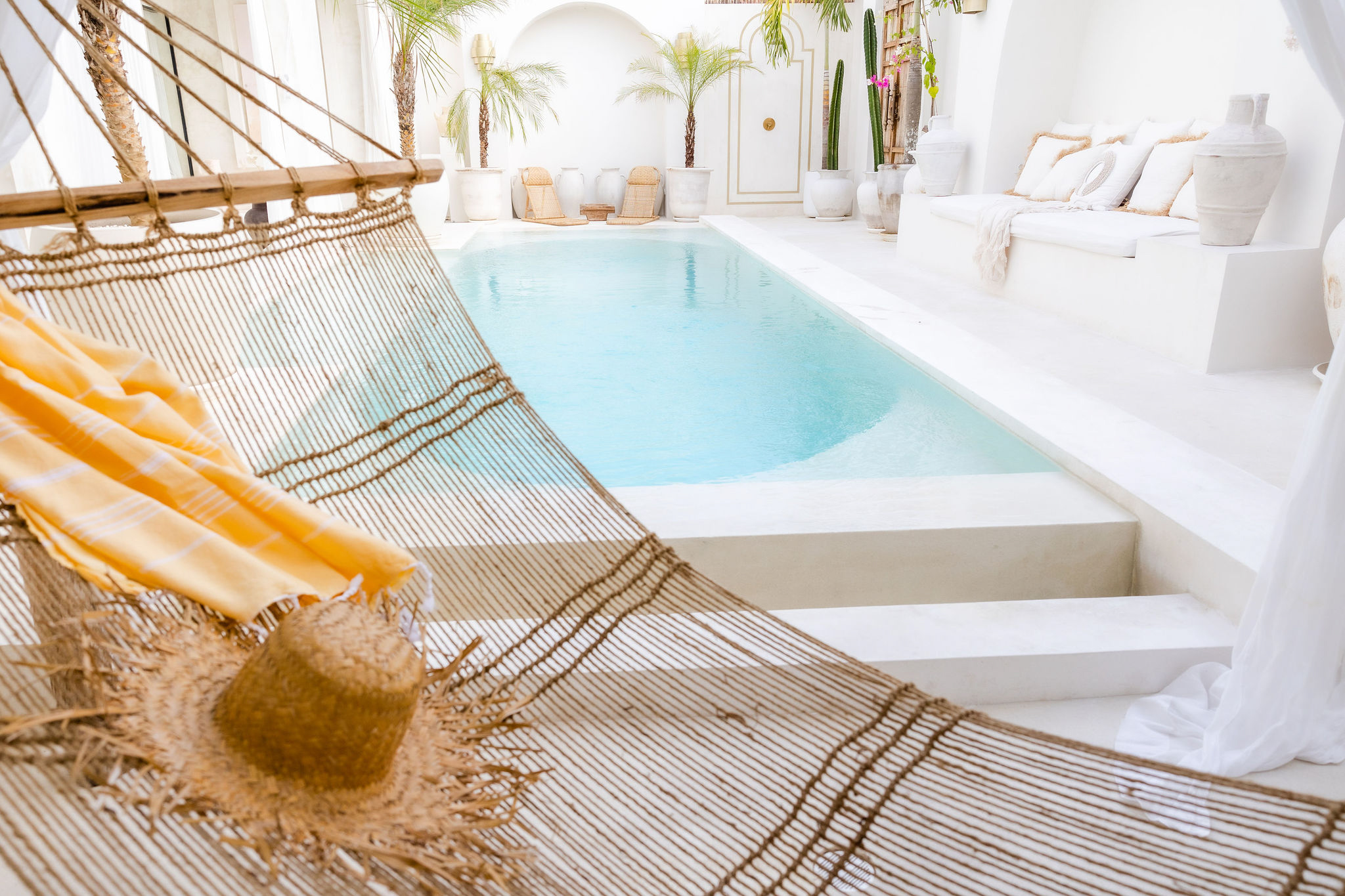Travel and lifestyle stock images featuring outdoor living area in a Bali villa with swimming pool and hammock, perfect for exotic travellers.