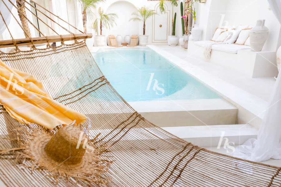 Travel stock photo featuring a beautiful villa with outdoor pool and hammock.