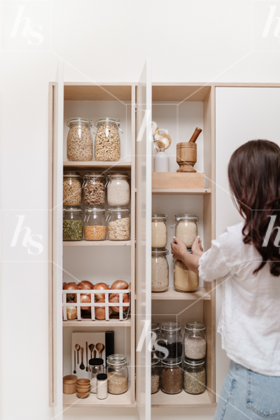 Stock image of woman organizingpantry perfect for professional organizers