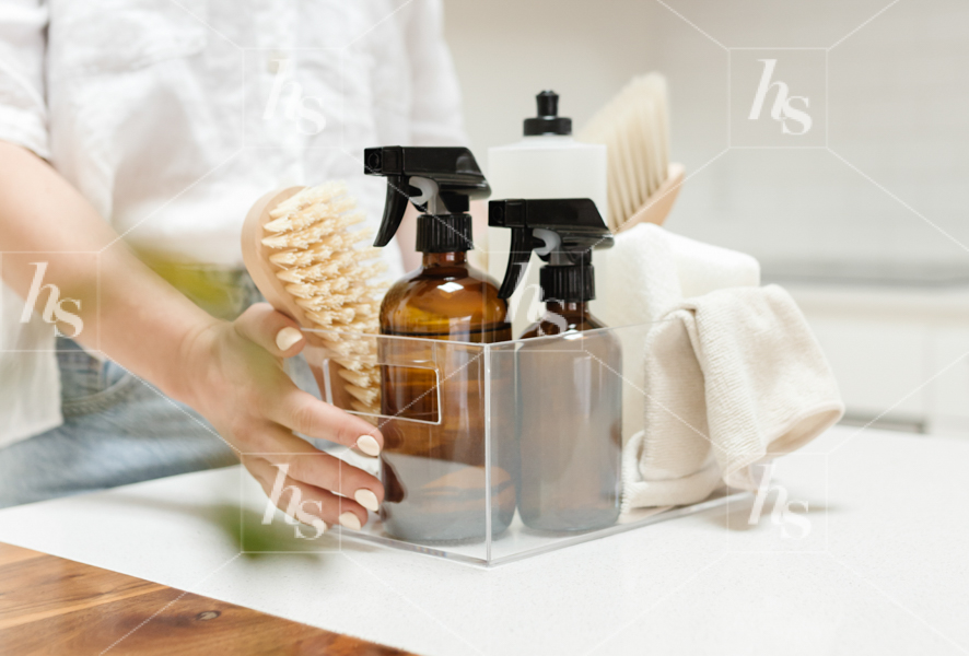 Styled tock photo of woman getting ready to clean using eco-conscious supplies