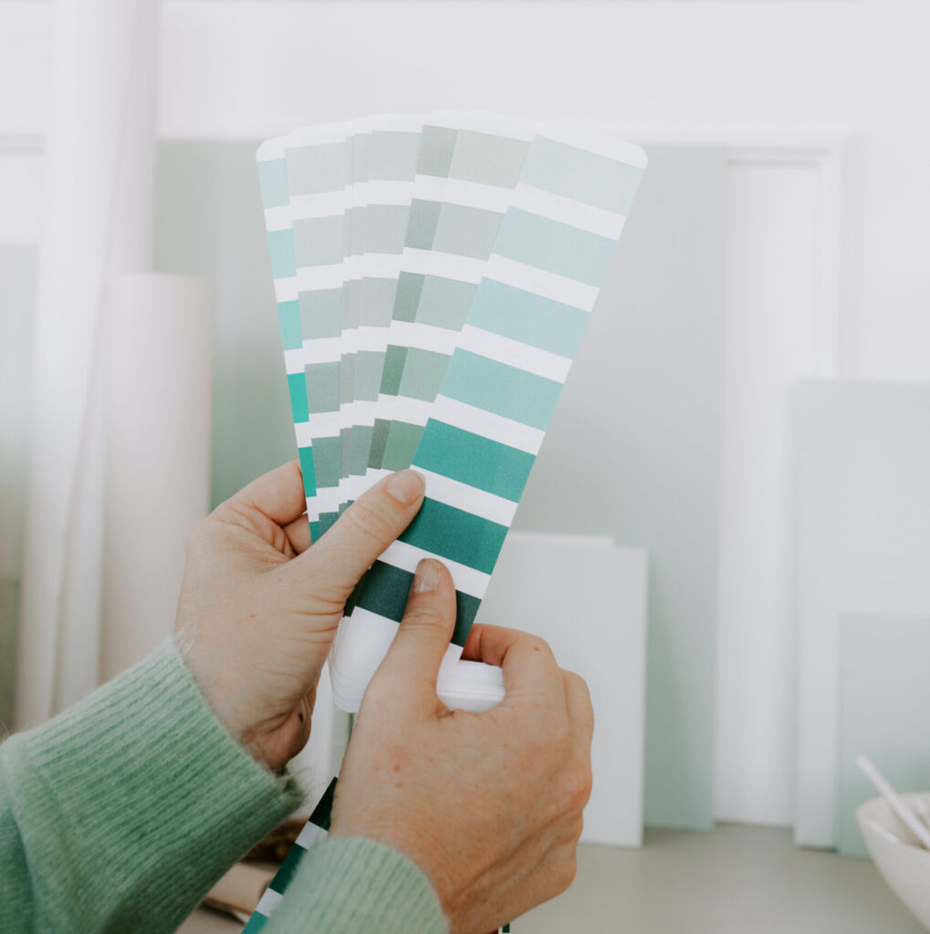 Stock image of woman holding teal paint swatches perfect for creative designers