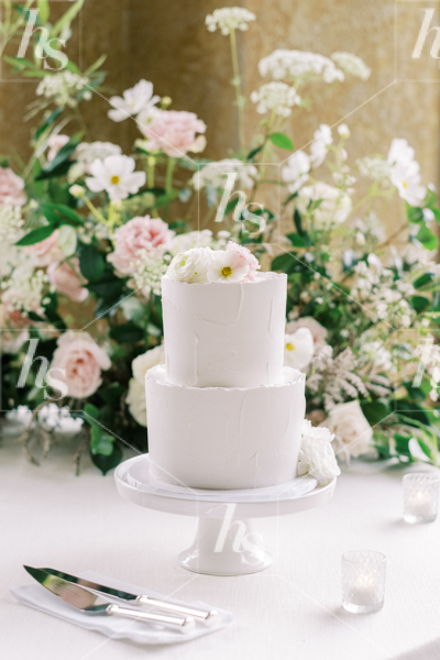 Wedding cake surrounded by flowers, a stylish stock image perfect for event and wedding planners.