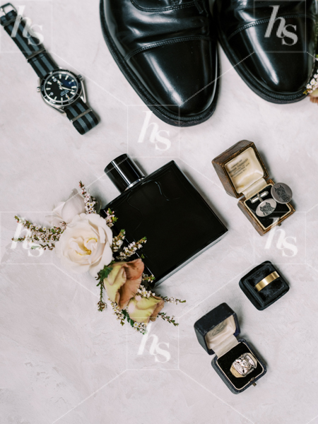 Groom inspired wedding flatlay with perfume and rings
