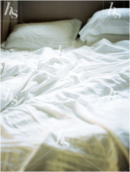 Stock image of a messed up bed white sheets