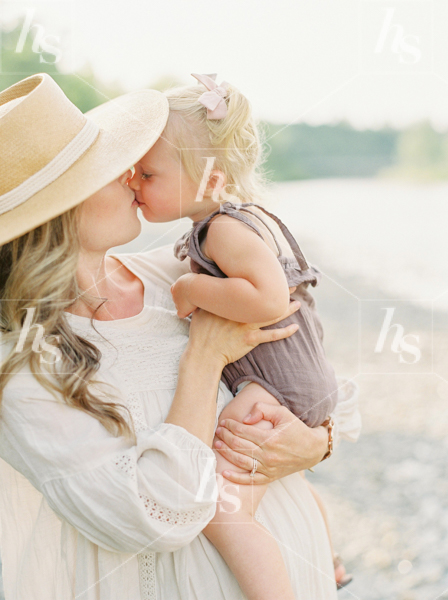 Mom's showing affection to toddler in her arms. Motherhood stock photo.