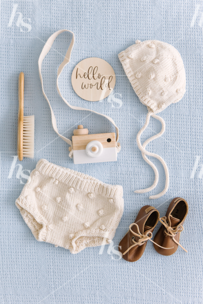 Baby boy clothes and toys flatlay on blue background