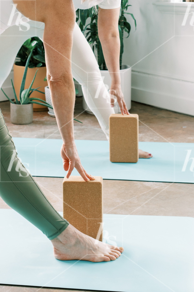 2 women stretching using blocks in our health and wellness stock photos