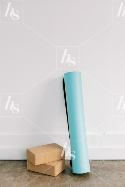 Stock image of blue yoga mat and blocks against wall, perfect for fitness instructors and wellness bloggers