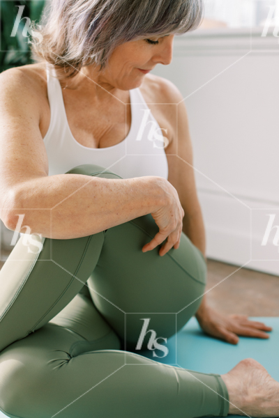 Woman wearing green leggings stretching in our latest collection of health and wellness stock photos for entrepreneurs