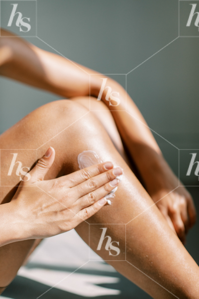 Woman applying lotion to her leg in this collection of stock photos for beauty brands.