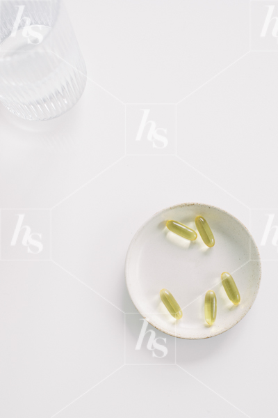 Minimal stock photo flatlay of vitamins on plate perfect for wellness coaches and bloggers.