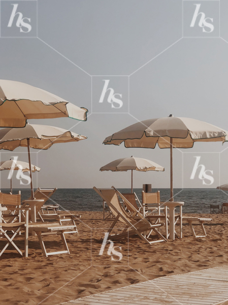Looking for a relaxing day at the beach? Here's an photo of beach chairs and umbrellas on a sandy beach in Italy.