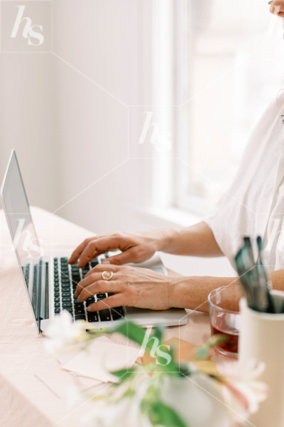 A woman working at desk in this collection of workspace stock photos for creative artists and designers.