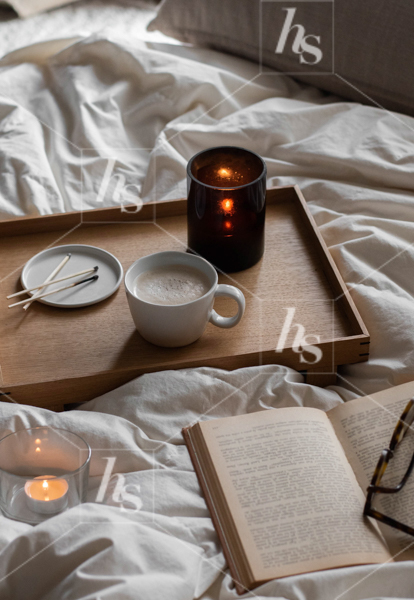 Reading in bed with cozy candles and drink, part of moody fall aesthetic stock photos and videos collection: Cabin Retreat.