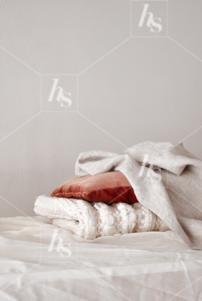 Stack of white and terracotta red colored fabrics on table, a styled image part of Terracotta fall travel stock photos collection. Available on Haute Stock!