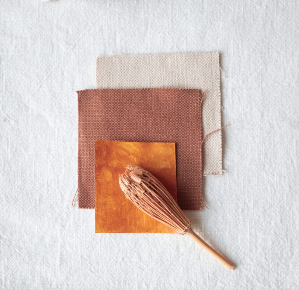 Close-up of autumnal fabric swatches in terracotta and burnt orange colors on textured background, part of fall travel stock photos collection. Perfect for interiordesigners.